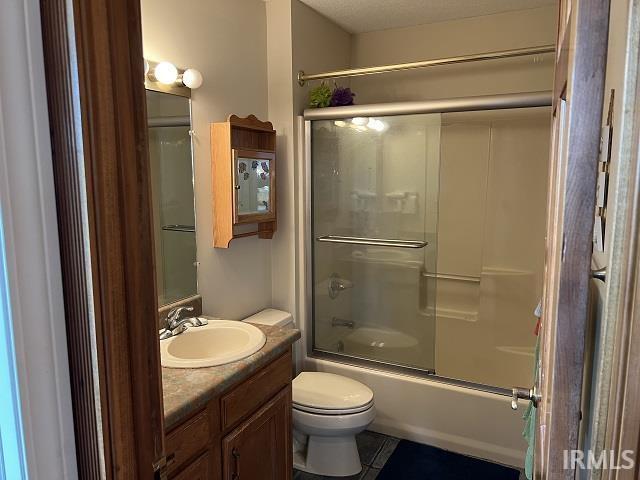 720 Ln 800 Snow Lk, Fremont, IN 46737 - bathroom featuring vanity, shower / bath combination with glass door, toilet, and tile patterned flooring