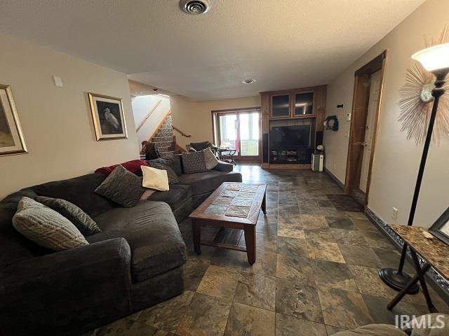 720 Ln 800 Snow Lk, Fremont, IN 46737 - living area with stone tile flooring, stairs, and baseboards