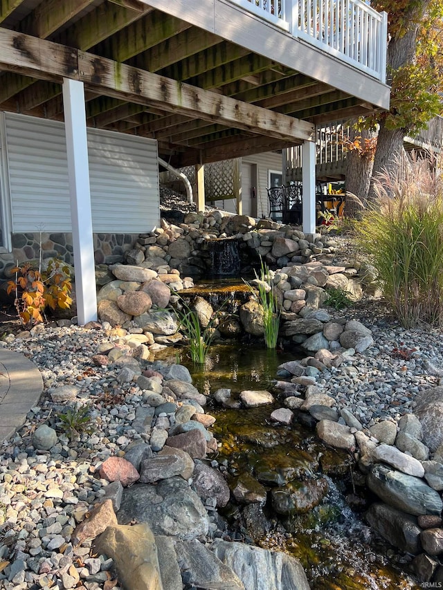 view of patio / terrace featuring a wooden deck and a garden pond