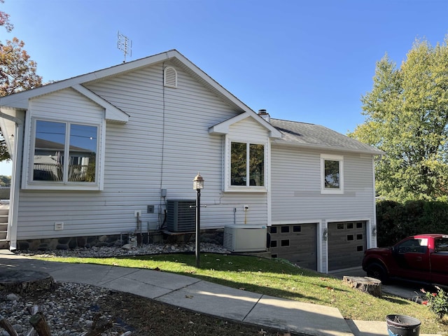 720 Ln 800 Snow Lk, Fremont, IN 46737 - view of home's exterior with a garage, cooling unit, a chimney, and a shingled roof