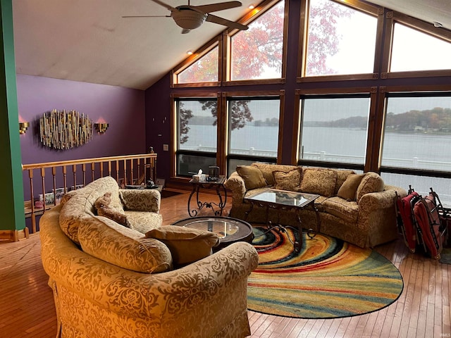 living room with hardwood / wood-style floors, a water view, high vaulted ceiling, and ceiling fan