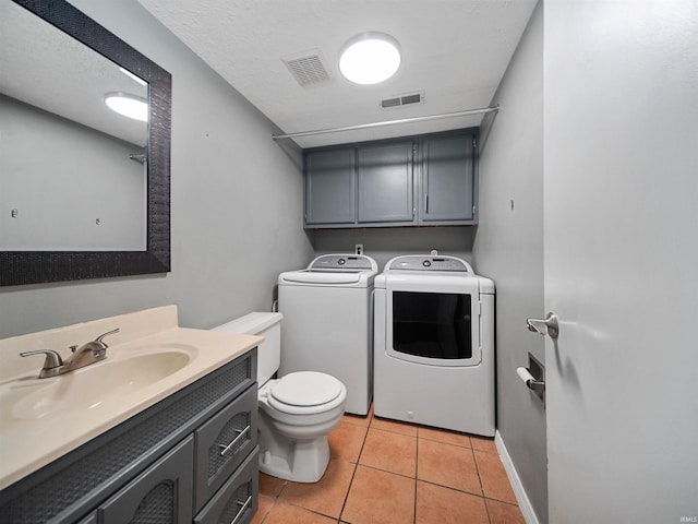 bathroom featuring a textured ceiling, separate washer and dryer, toilet, vanity, and tile patterned flooring