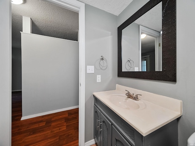 bathroom featuring vanity, a textured ceiling, and hardwood / wood-style flooring