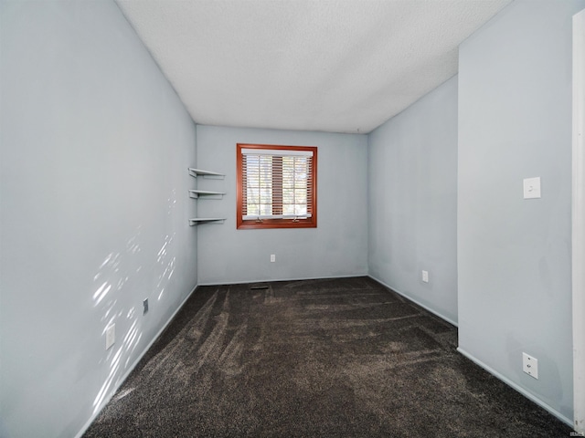 carpeted empty room featuring a textured ceiling