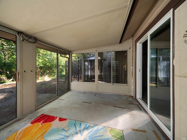 unfurnished sunroom featuring vaulted ceiling