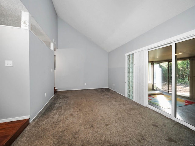 empty room with lofted ceiling and dark colored carpet