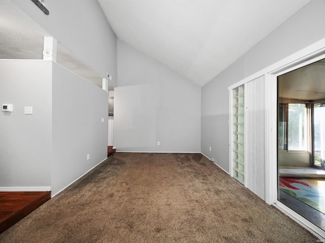 interior space featuring lofted ceiling and dark carpet