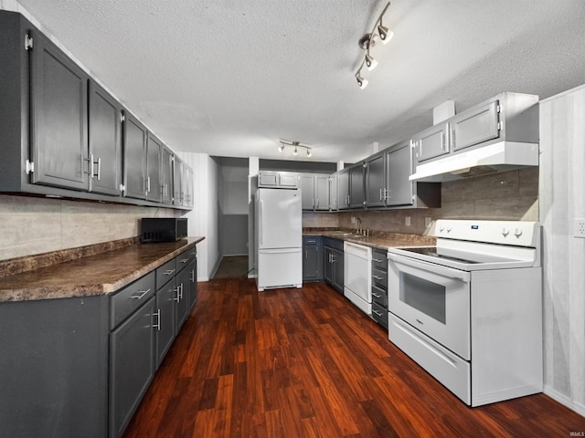 kitchen with white appliances, gray cabinetry, sink, a textured ceiling, and dark hardwood / wood-style floors