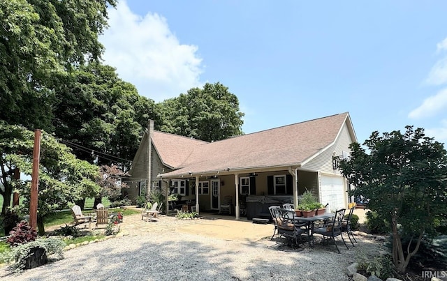 3810 E 100 N, Flora, IN 46929 - back of house with a patio area, outdoor dining area, roof with shingles, and a garage