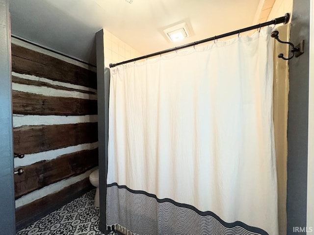 3810 E 100 N, Flora, IN 46929 - bathroom featuring curtained shower, toilet, and wooden walls