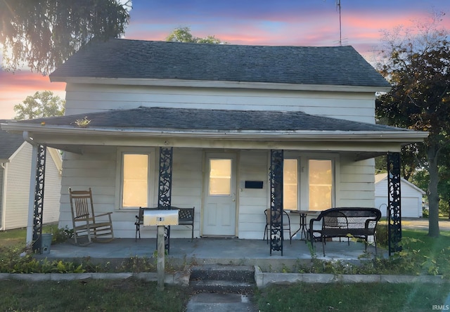 bungalow-style home featuring covered porch and a garage