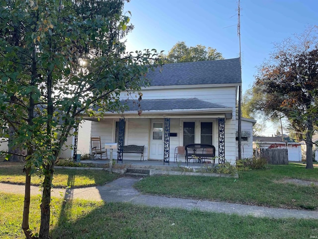 bungalow-style home with a front yard and covered porch