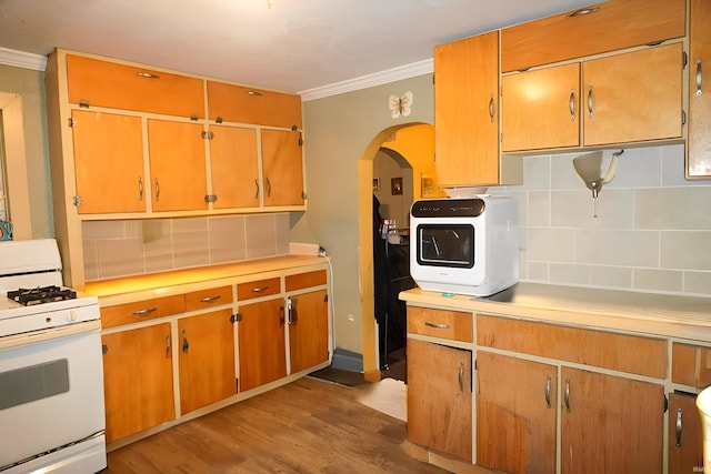 kitchen with backsplash, ornamental molding, white range with gas cooktop, and light wood-type flooring