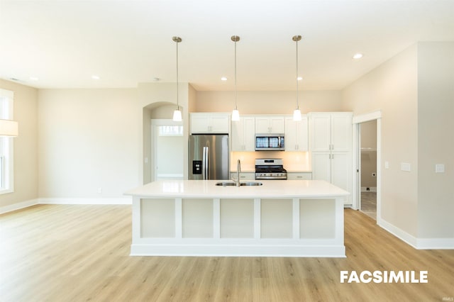 kitchen featuring a large island, white cabinets, hanging light fixtures, light wood-type flooring, and stainless steel appliances