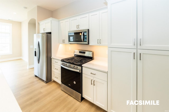 kitchen with white cabinetry, light hardwood / wood-style floors, and stainless steel appliances