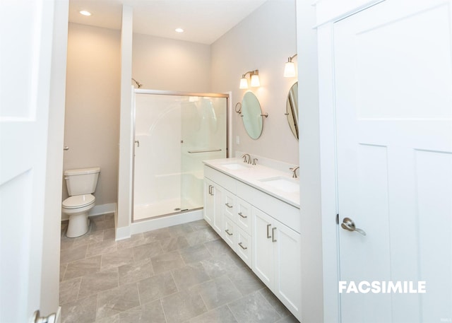 bathroom with vanity, toilet, and a shower with door