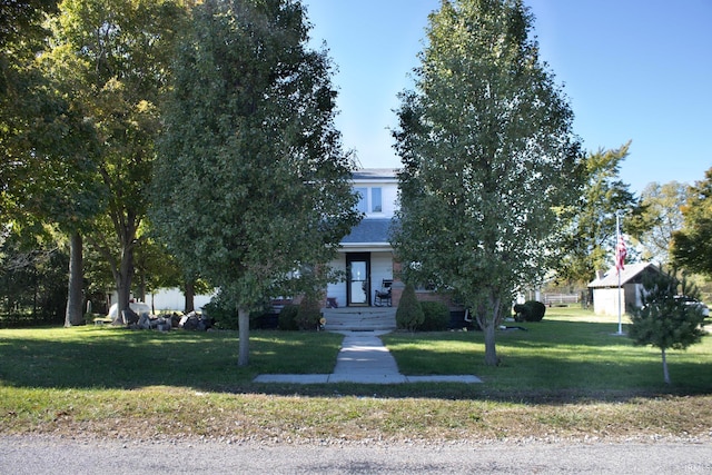 view of property hidden behind natural elements featuring a front lawn