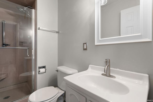 bathroom with a shower with door, vanity, and toilet