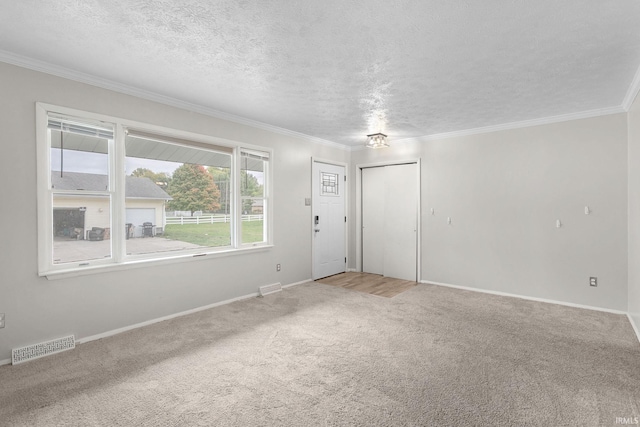 carpeted spare room with crown molding and a textured ceiling