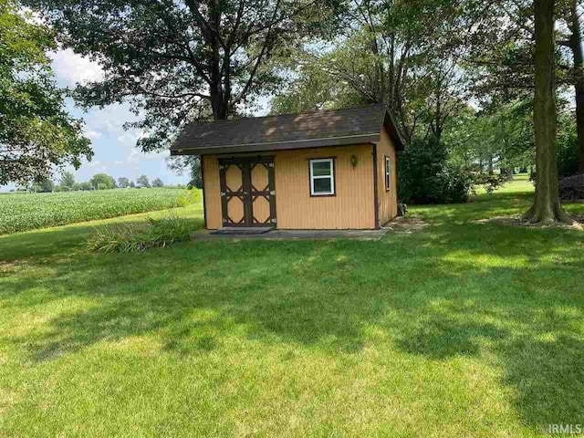 view of outdoor structure featuring a yard and a rural view