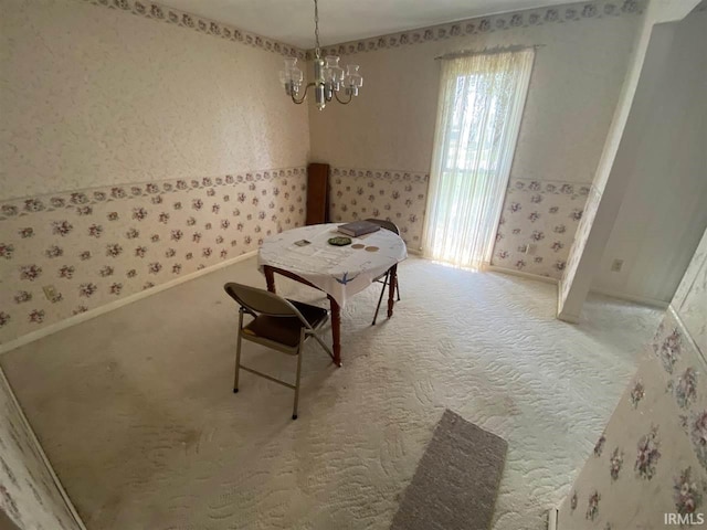 dining space featuring carpet and an inviting chandelier