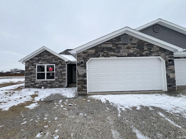 single story home with a garage and stone siding