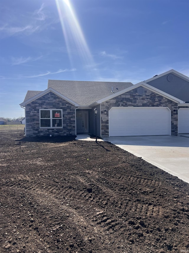 ranch-style home featuring driveway, stone siding, and a garage