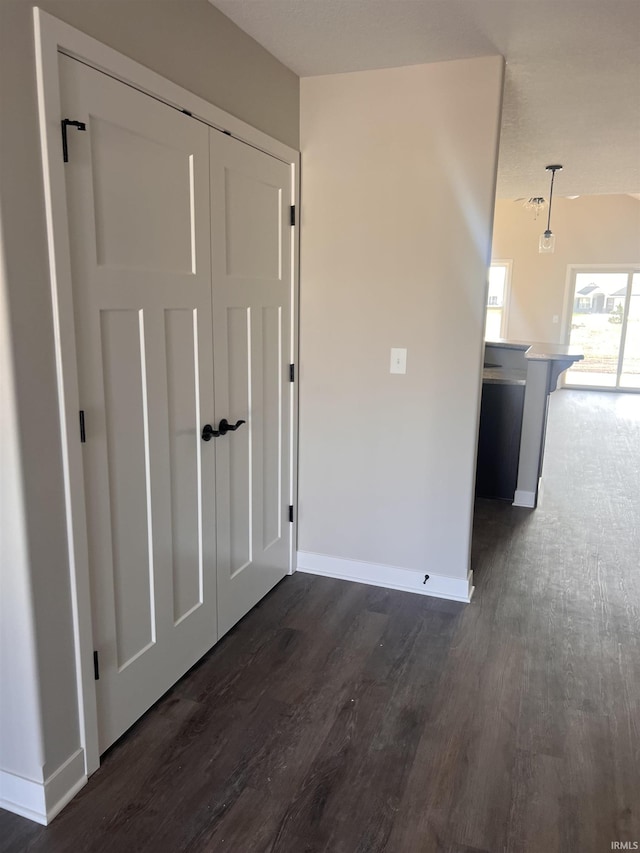 empty room with dark wood-type flooring and baseboards