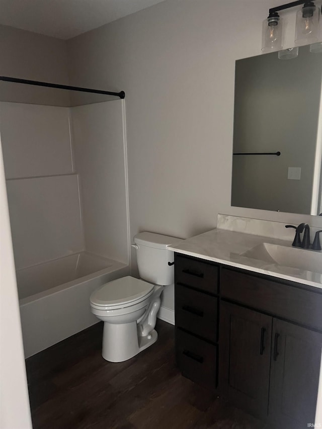full bath with wood finished floors, shower / washtub combination, vanity, baseboards, and toilet