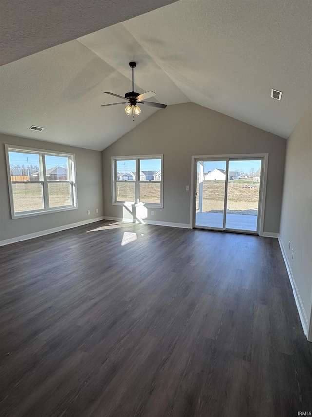unfurnished living room featuring visible vents, a ceiling fan, dark wood-style floors, and vaulted ceiling