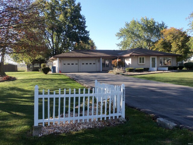 single story home featuring a front lawn and a garage