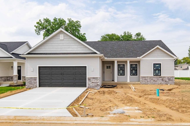 18609 Bracken Fern Ct, South Bend, IN 46637 - craftsman house with covered porch, stone siding, an attached garage, driveway, and roof with shingles
