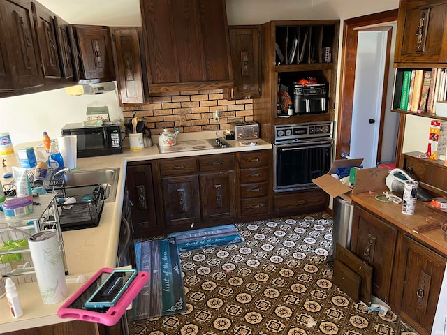 kitchen featuring dark brown cabinetry, black appliances, tasteful backsplash, and custom exhaust hood