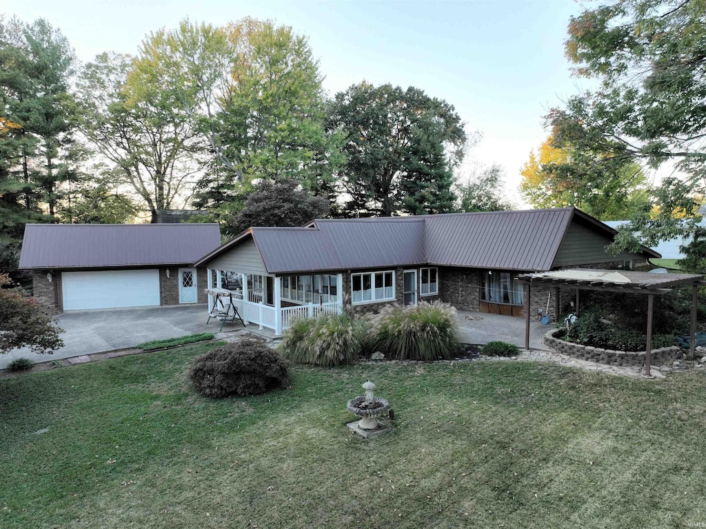 ranch-style house featuring an attached garage, stone siding, metal roof, and a front yard