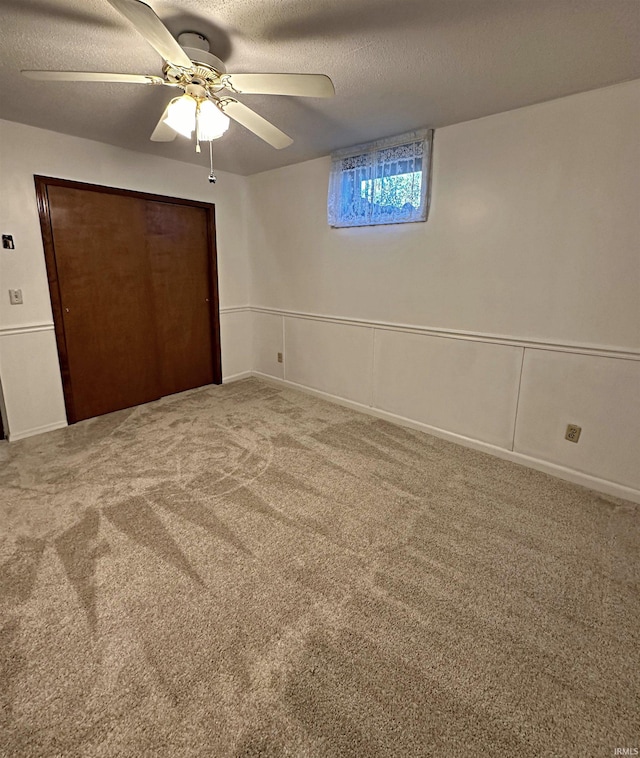 unfurnished bedroom with a closet, carpet floors, a textured ceiling, and ceiling fan