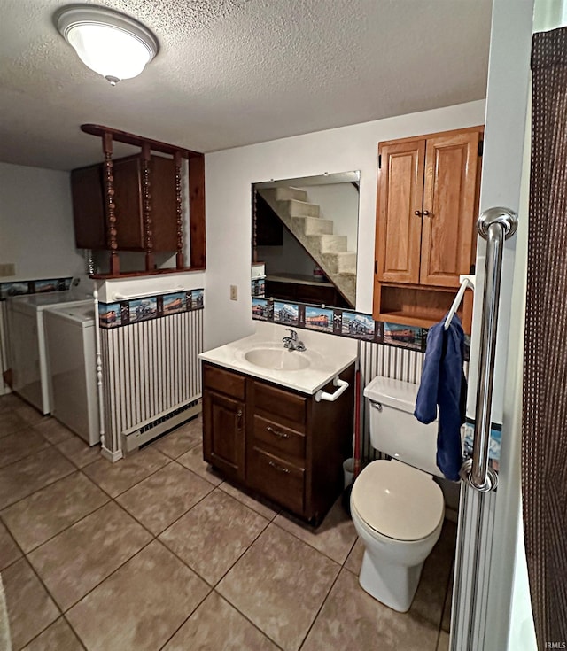 bathroom featuring vanity, toilet, a textured ceiling, and tile patterned flooring