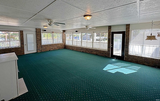 unfurnished sunroom featuring a paneled ceiling and ceiling fan