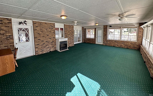 unfurnished sunroom featuring a paneled ceiling and ceiling fan