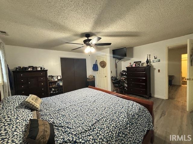 bedroom featuring a textured ceiling, hardwood / wood-style flooring, and ceiling fan