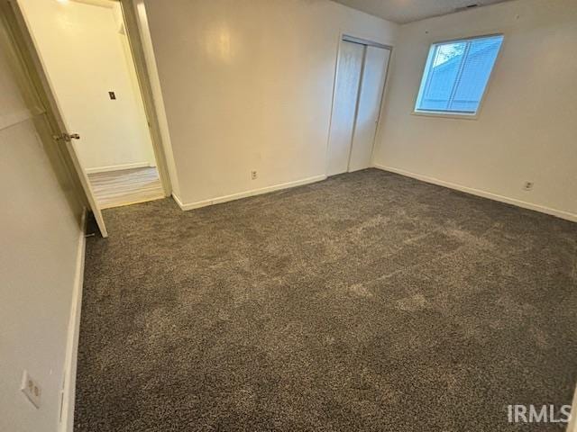 unfurnished bedroom with dark carpet