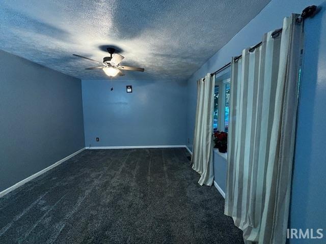 carpeted spare room with ceiling fan and a textured ceiling