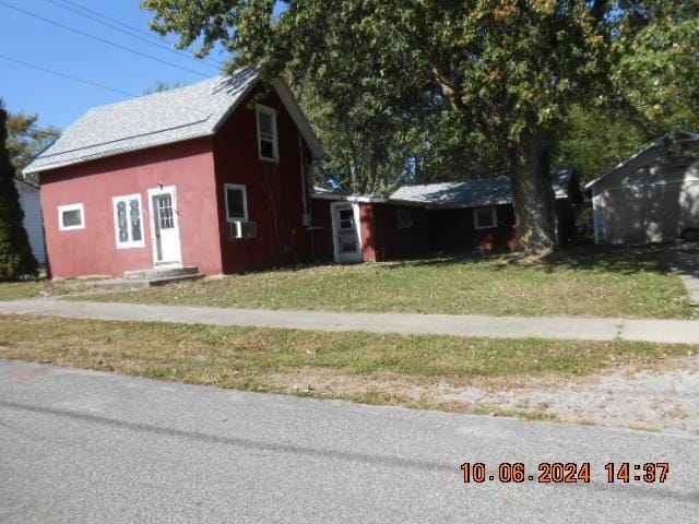 view of front of home featuring cooling unit and a front lawn