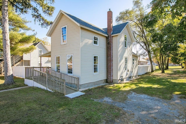 view of property exterior featuring a yard and a deck