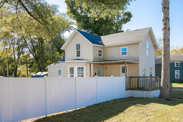 rear view of property with a deck and a lawn