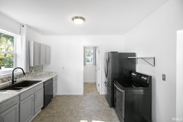 kitchen featuring stainless steel appliances, sink, and gray cabinetry