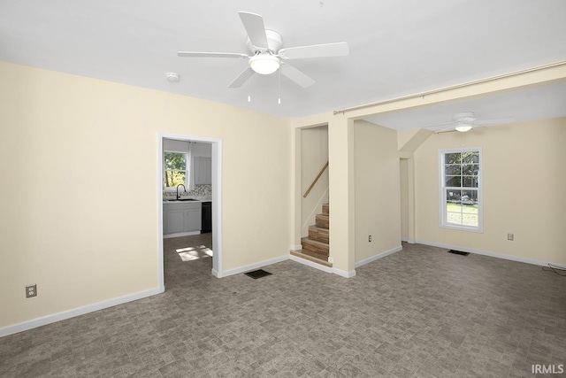 interior space with ceiling fan, carpet, sink, and plenty of natural light