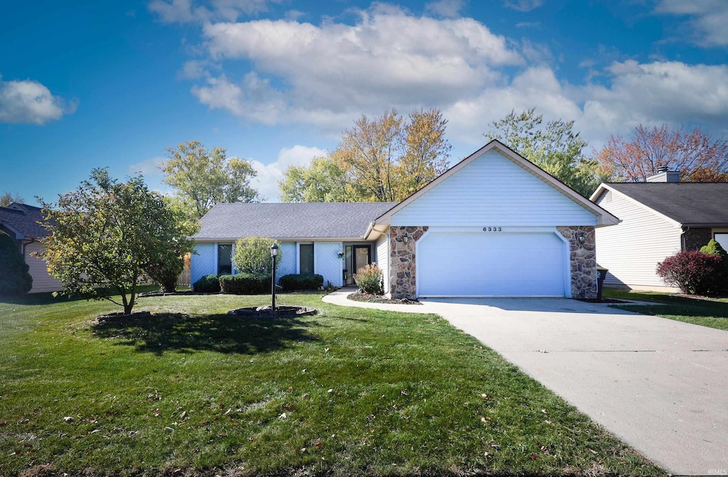 ranch-style house featuring a garage and a front yard