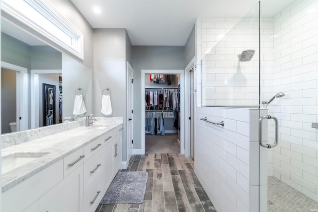 bathroom featuring a shower with door, vanity, and wood-type flooring