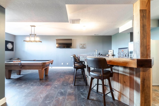 playroom featuring a textured ceiling, billiards, and indoor bar