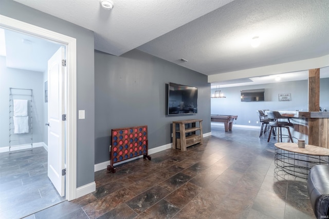 living room featuring bar area, a textured ceiling, and billiards